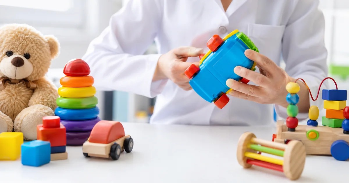 Profissional verifica brinquedo colorido em mesa de inspeção